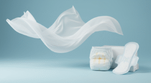 A close-up image showcasing a roll of white nonwoven fabric being processed with hot air treatment. The fabric is gently moving through a specialized machine, demonstrating the process of thermal bonding and enhancing its properties for use in sanitary products like diapers and pads.