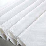 A close-up of the textured surface of Embossed Spunlace Non Woven Fabric, highlighting its unique diamond pattern for enhanced absorbency.