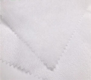 A large, pristine roll of soft disposable spunlace fabric ready for distribution, highlighting its quality and smooth texture.