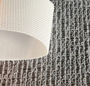 Macro view of the Elastic Non Woven Side Tape being pulled to show the high recovery elastic properties of the nonwoven elastic material.