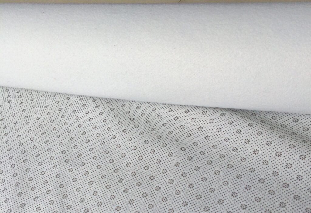 A close-up view of spunbond embossed fabric showing its distinct pattern and soft texture, which is engineered for use in high-performance hygiene products.
