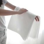 Hand holding a sample of the thick, dot embossed embossed nonwoven for wipes, demonstrating its superior softness and low linting properties.